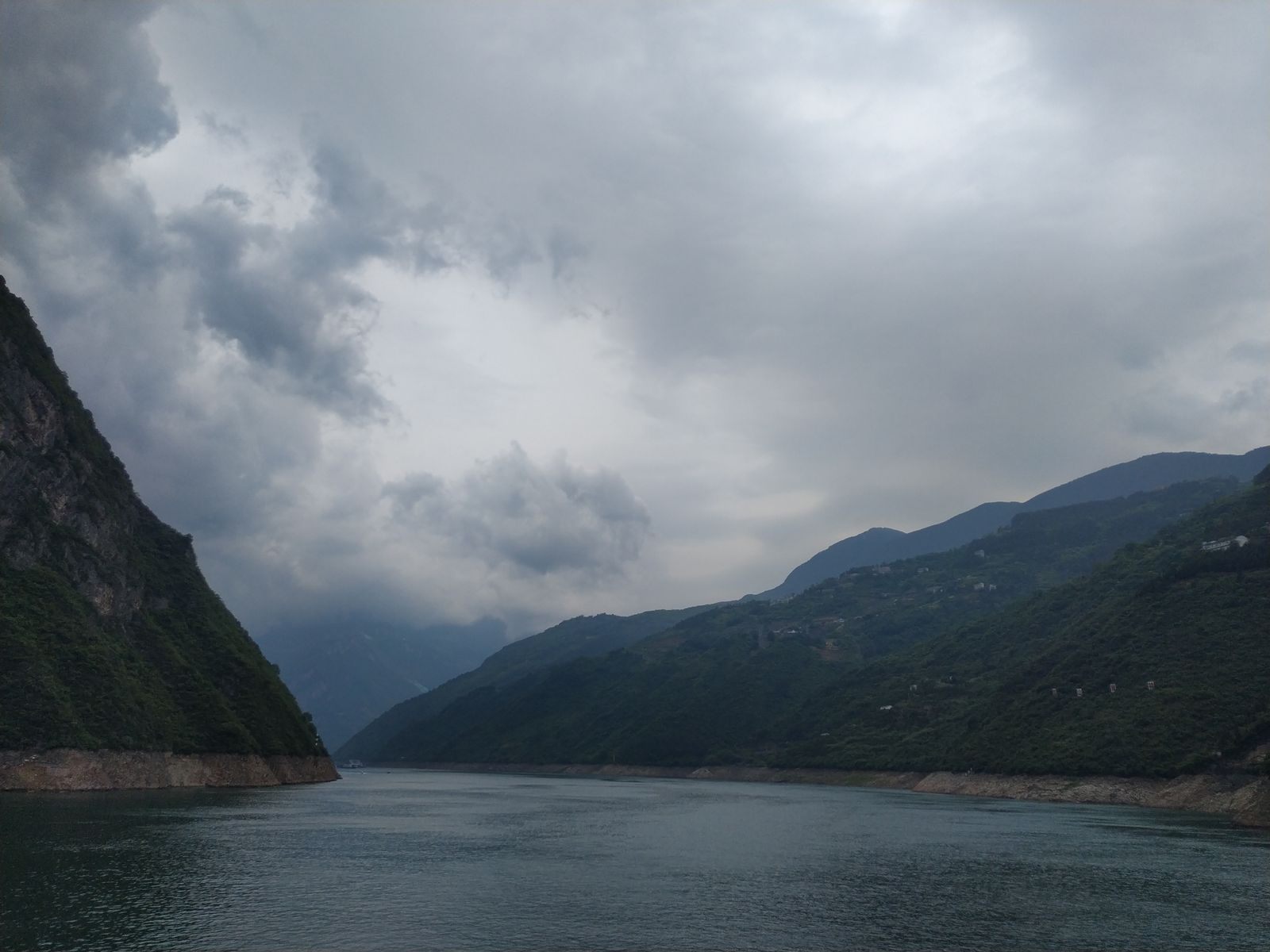 Storm clouds over a steep, forested gorge on the Yangtze River
